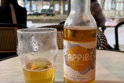 Glas and bottle gluten-free cider of Appie on a table in a bar