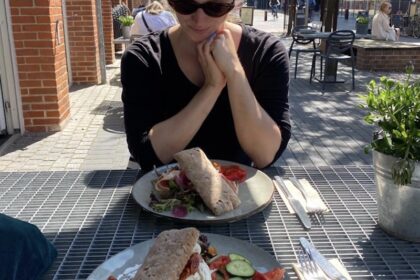 Frau am Tisch vor zwei glutunfreien Sandwiches in Holstebro in Dänemark.