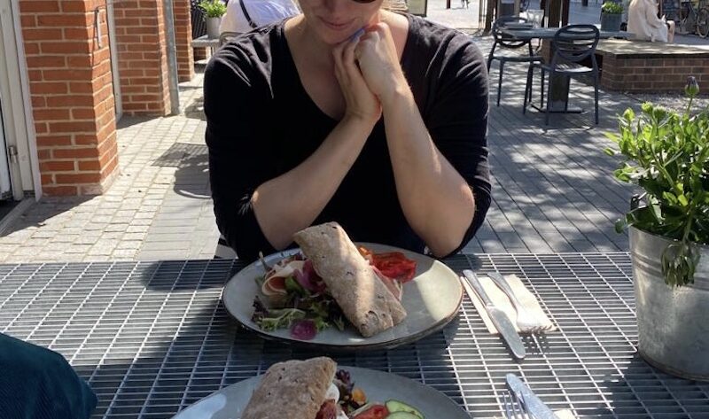 Frau am Tisch vor zwei glutunfreien Sandwiches in Holstebro in Dänemark.