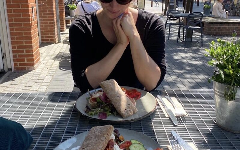 Frau am Tisch vor zwei glutunfreien Sandwiches in Holstebro in Dänemark.