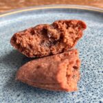 Glutenfreie Madeleines mit Schokocremefüllug auf blauem Teller.