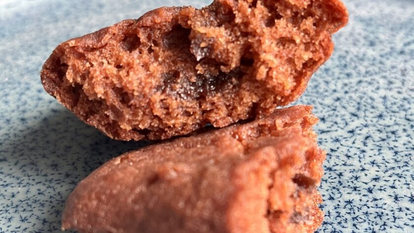 Glutenfreie Madeleines mit Schokocremefüllug auf blauem Teller.