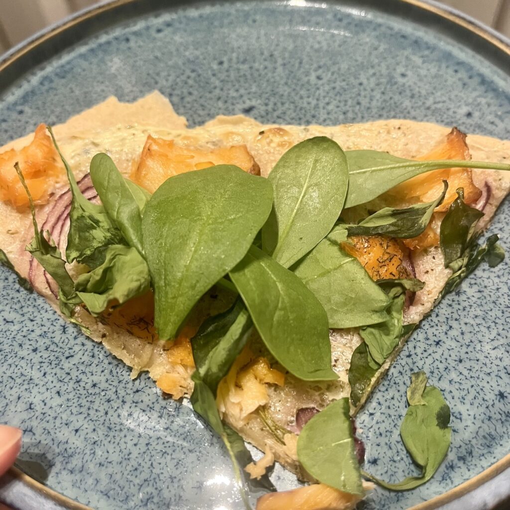 Flammkuchen glutenfrei, mit Spinat auf Teller angerichtet