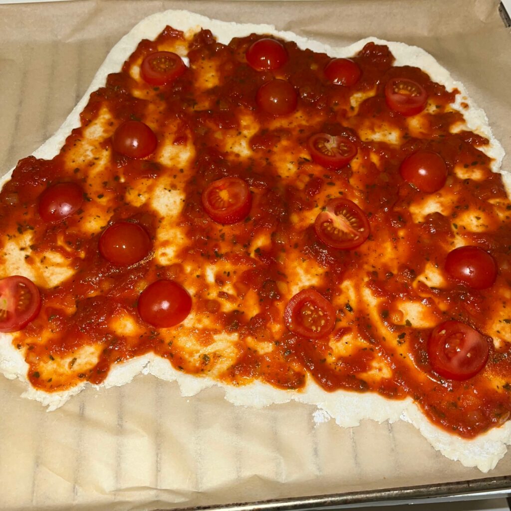 Pizzateig selbstgemacht und glutenfrei mit Tomatensauce bestrichen