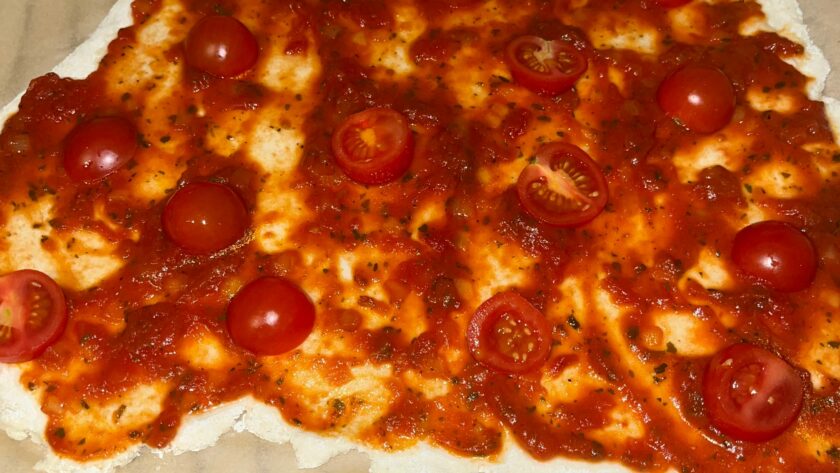 Pizzateig selbstgemacht und glutenfrei mit Tomatensauce bestrichen