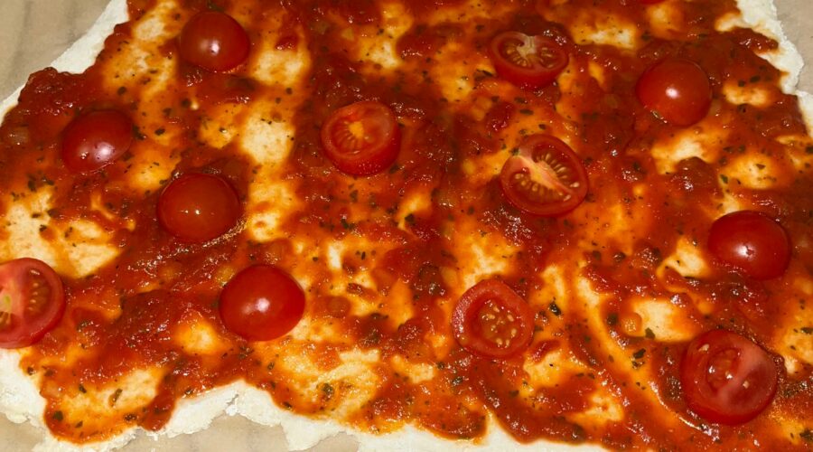 Pizzateig selbstgemacht und glutenfrei mit Tomatensauce bestrichen