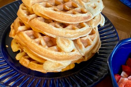 Turm glutenfreier Waffeln auf blauem Teller.