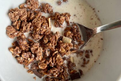 Glutenfreies Müsli in einer Schale mit Milch und Löffel.