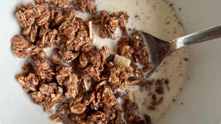 Glutenfreies Müsli in einer Schale mit Milch und Löffel.