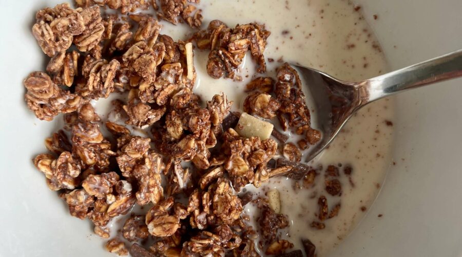 Glutenfreies Müsli in einer Schale mit Milch und Löffel.